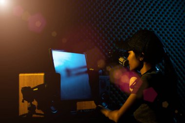 Genç Yetişkin Youtube 'da bir cover şarkısı söylüyor. Kadınlar sosyal medyayı elektronik oyun klavyesi, fare, monitör, hoparlör, kamera, stüdyo, koyu sarı tema gibi profesyonel ekipmanlarla birleştiriyor.