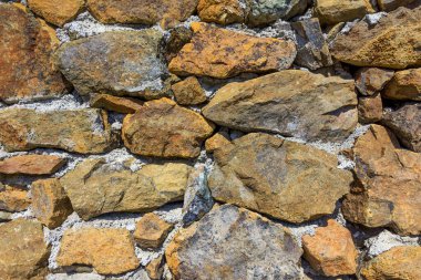 Çimentolu taş duvar. Dekoratif eğri büğrü taş gerçek bir taş duvardır..