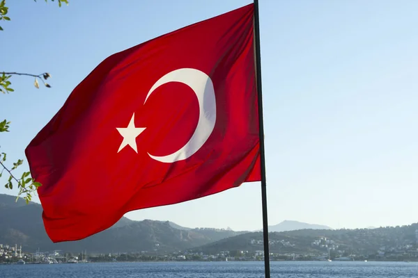 Flag of Turkey on a background of sky and mountains