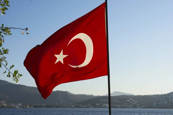 Flag of Turkey on a background of sky and mountains