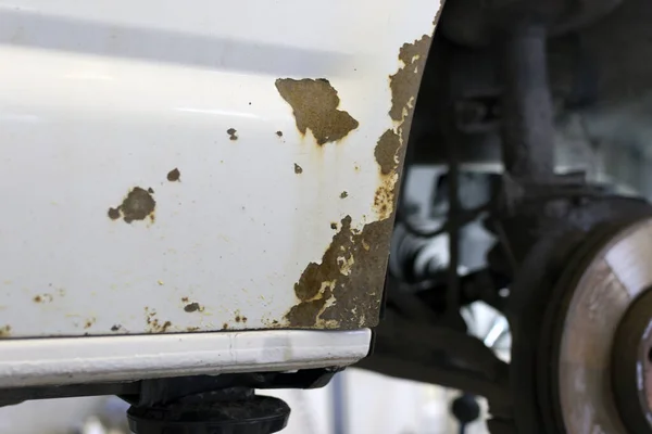 Corrosion on a car body. Rust on a car close-up.
