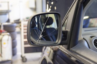 Araba servisinde dikiz aynası kırık bir araba. Arabanın aynasında çatlaklar var. Sigorta araba tamiratı..