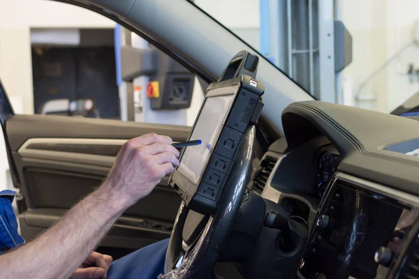 プロの整備士は車サービスで車を診断します 自動車の電気的診断 ストック写真