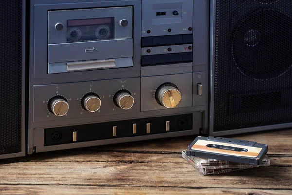 木製のテーブルの上に古いテープレコーダーとカセット — ストック写真