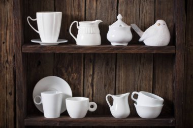 Eski siyah ahşap arka planda beyaz mutfak bulaşık takımı 