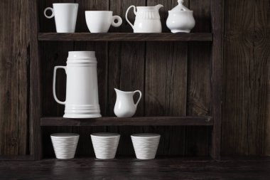 Eski siyah ahşap arka planda beyaz mutfak bulaşık takımı