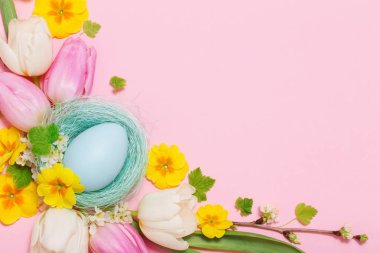 Pembe arka planda Paskalya yumurtaları ve bahar çiçekleri