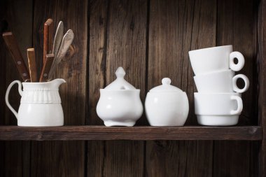 Eski siyah ahşap arka planda beyaz mutfak bulaşık takımı