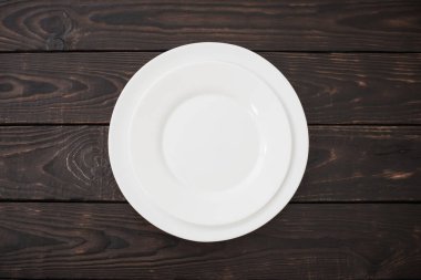 Eski siyah ahşap arka planda beyaz seramik tabaklar