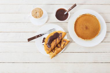 Çikolatalı gözleme ve beyaz ahşap arka planda kahve.