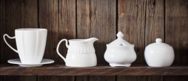 Eski siyah ahşap arka planda beyaz mutfak bulaşık takımı