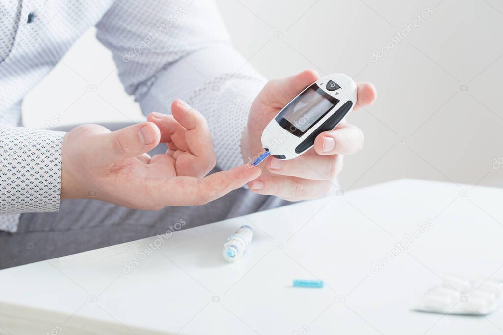 person measures blood sugar with glucometer
