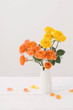 Beyaz arkaplanda beyaz vazodaki güller