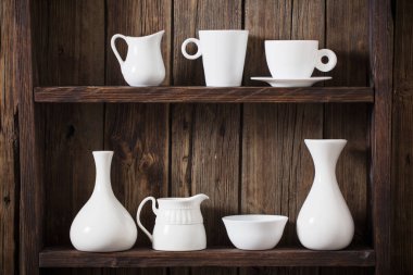 Eski siyah ahşap arka planda beyaz mutfak bulaşık takımı