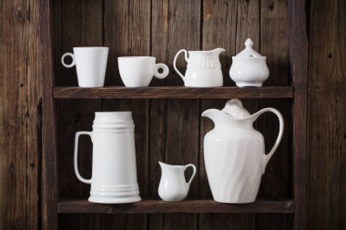 Eski siyah ahşap arka planda beyaz mutfak bulaşık takımı