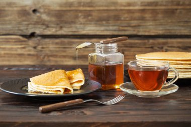 Ballı patlamalar ve eski ahşap arka planda bir fincan çay.