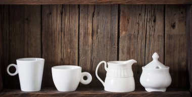 Eski siyah ahşap arka planda beyaz mutfak bulaşık takımı