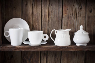 Eski siyah ahşap arka planda beyaz mutfak bulaşık takımı