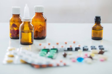 İlaç şişesi beyaz arka plandaki masada.