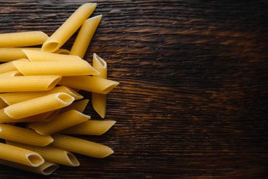 Tahta arka planda çiğ İtalyan makarnası.