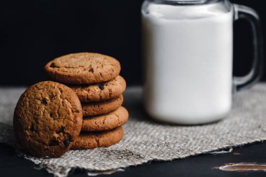 Koyu arka planda sütlü yulaf ezmeli çikolatalı kurabiyeler.