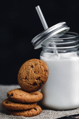 Koyu arka planda sütlü yulaf ezmeli çikolatalı kurabiyeler.