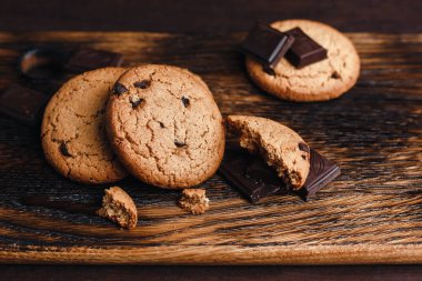 Koyu arkaplan görünümlü çikolatalı yulaflı kurabiyeler metin için kullanılacak.