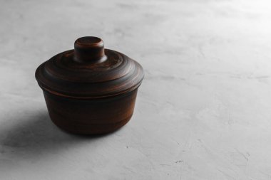 Üstü aydınlık beton bir zeminde kumaşlı çamur tenceresi.