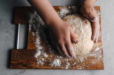 Pişirme işlemi için ham hamur hazırlama kız unları siyah arka planda serpiştirir