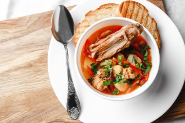 Fasulyeli çorba ve beyaz tabakta ekmekli et.