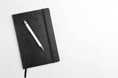 Not defteri siyah, beyaz arkaplanda kalem üstü görünümü ile kapatıldı. Metin için boşluk