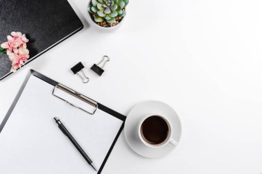 Beyaz arka planda çiçekli kahve fincanlı siyah ofis tableti. Metin için boşluk