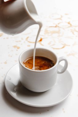 Krema, kahve ile dolu beyaz bir fonda koyu kahveye dökülür. etiket için bir yer