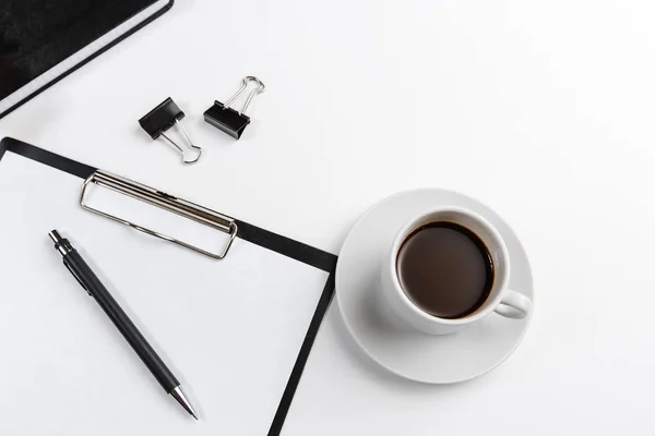 Beyaz arka planda çiçekli kahve fincanlı siyah ofis tableti. Metin için boşluk