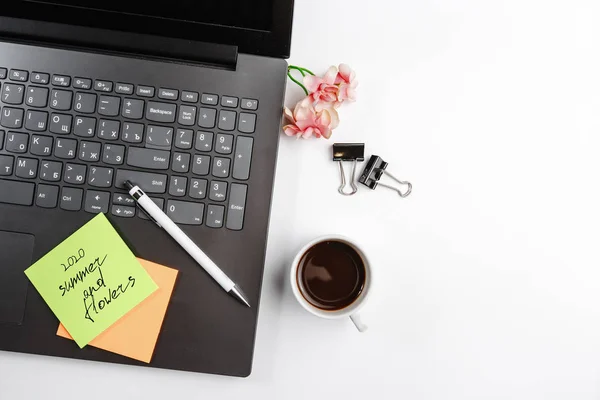 Ofis dizüstü bilgisayarı siyah Notepad açık kalem kahve çiçeği ve ofis renkli etiketler beyaz arka planda. Metin için boşluk