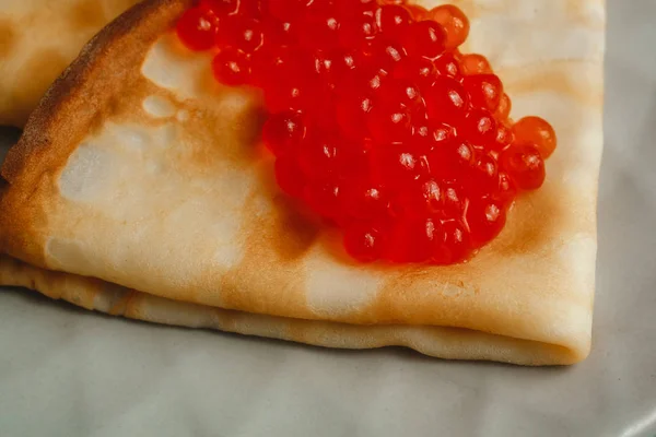 Maslenitsa Maslenitsa week is a holiday of food. Pancakes with red caviar close-up. macro