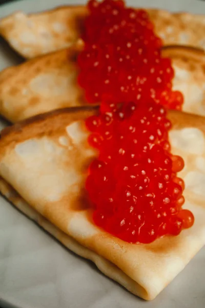 Maslenitsa Maslenitsa week is a holiday of food. Pancakes with red caviar close-up. macro