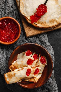 Maslenitsa Maslenitsa haftası yemek tatilidir. Tahta tabakta kırmızı havyarlı gözleme. Yukarıdan manzara. Yan görünüş. Metin için boşluk
