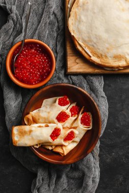 Maslenitsa Maslenitsa haftası yemek tatilidir. Tahta tabakta kırmızı havyarlı gözleme. Yukarıdan manzara. Yan görünüş. Metin için boşluk