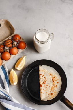 Tavuğun yanında ahududu reçelli krep, tavuklu yumurta çırpma ve limonlu hafif beton arka planda bir tabakta. Yukarıdan manzara. Yan görünüş. Metin için boşluk