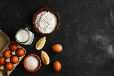 Krep yapmak için gerekli malzemeler. Tavuk yumurtası, çırpı, un, şeker, limon. Metin için yukarıdan görünüm