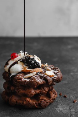 Bir tabak ahududu ve çikolatalı pudra şekerli ev yapımı çikolatalı waffle.