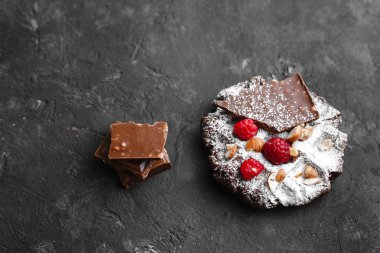 Bir tabak ahududu ve çikolatalı pudra şekerli ev yapımı çikolatalı waffle.