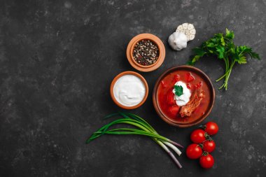 Ukrayna Borsch 'u. Pancar çorbası. Ukrayna mutfağı. Tahta bir tabakta. Karanlık arka planda. Yukarıdan manzara. Metnin için boş yer. Bir kase kremalı kırmızı pancar çorbası..