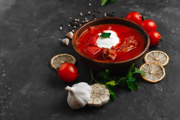 Ukrayna Borsch 'u. Pancar çorbası. Ukrayna mutfağı. Tahta bir tabakta. Karanlık arka planda. Yukarıdan manzara. Metnin için boş yer. Bir kase kremalı kırmızı pancar çorbası..