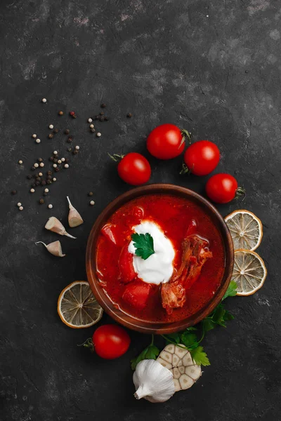 Ukrayna Borsch 'u. Pancar çorbası. Ukrayna mutfağı. Tahta bir tabakta. Karanlık arka planda. Yukarıdan manzara. Metnin için boş yer. Bir kase kremalı kırmızı pancar çorbası..
