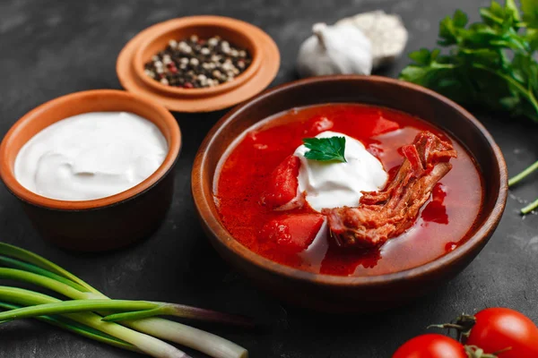Ukrayna Borsch 'u. Pancar çorbası. Ukrayna mutfağı. Tahta bir tabakta. Karanlık arka planda. Yukarıdan manzara. Metnin için boş yer. Bir kase kremalı kırmızı pancar çorbası..