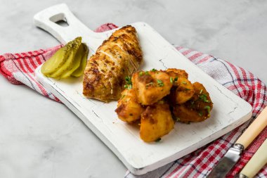 Patates ve otlarla bütün tavuğu köy usulü pişirdim. Üst görünüm, arka planda yan görünüm. Yakın plan ve orta plan. Metin için boşluk.