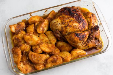 Patates ve otlarla bütün tavuğu köy usulü pişirdim. Üst görünüm, arka planda yan görünüm. Yakın plan ve orta plan. Metin için boşluk.