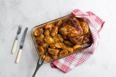 Patates ve otlarla bütün tavuğu köy usulü pişirdim. Üst görünüm, arka planda yan görünüm. Yakın plan ve orta plan. Metin için boşluk.